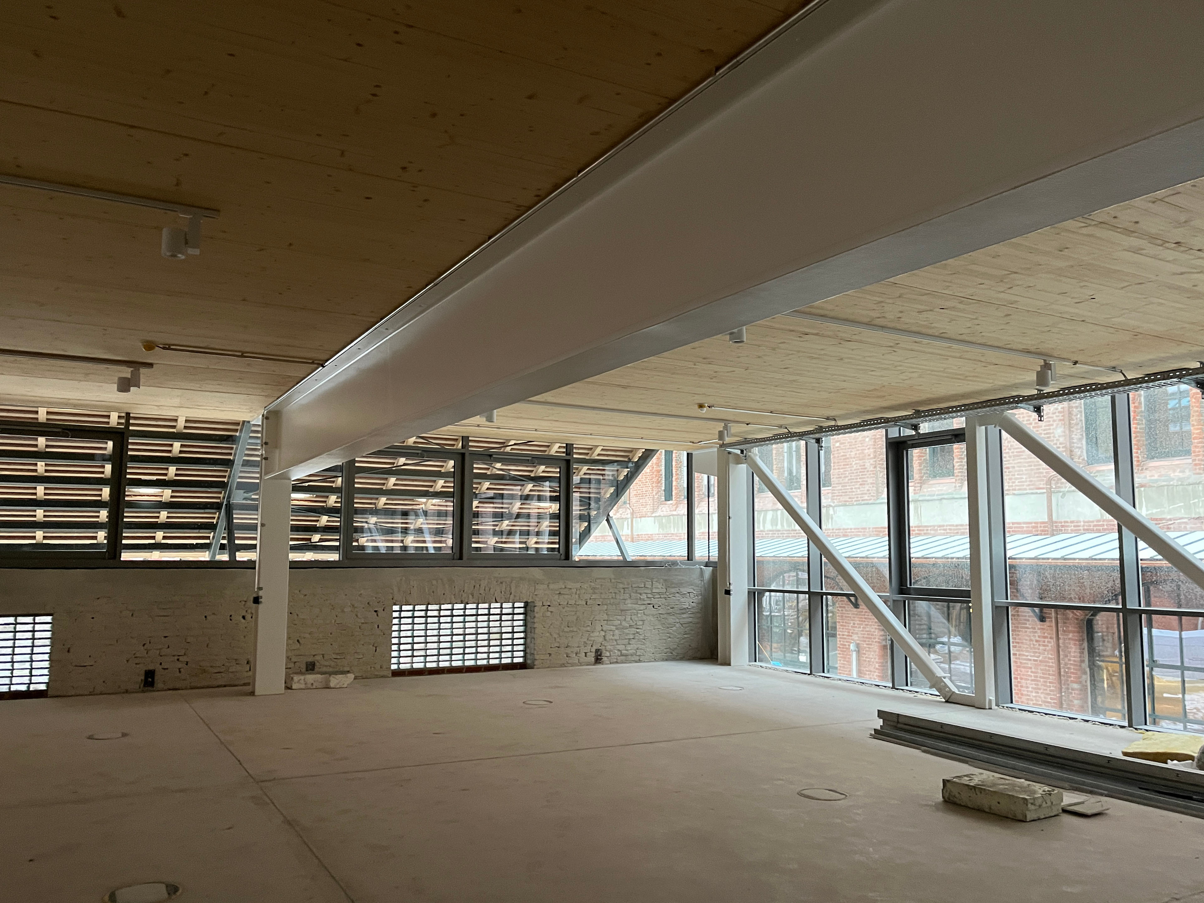 The construction progress at Postbahnhof Berlin shows the Beutel on the first upper floor with an empty, light-filled interior, large window fronts, exposed ceiling structures, and a view of the inner courtyard.