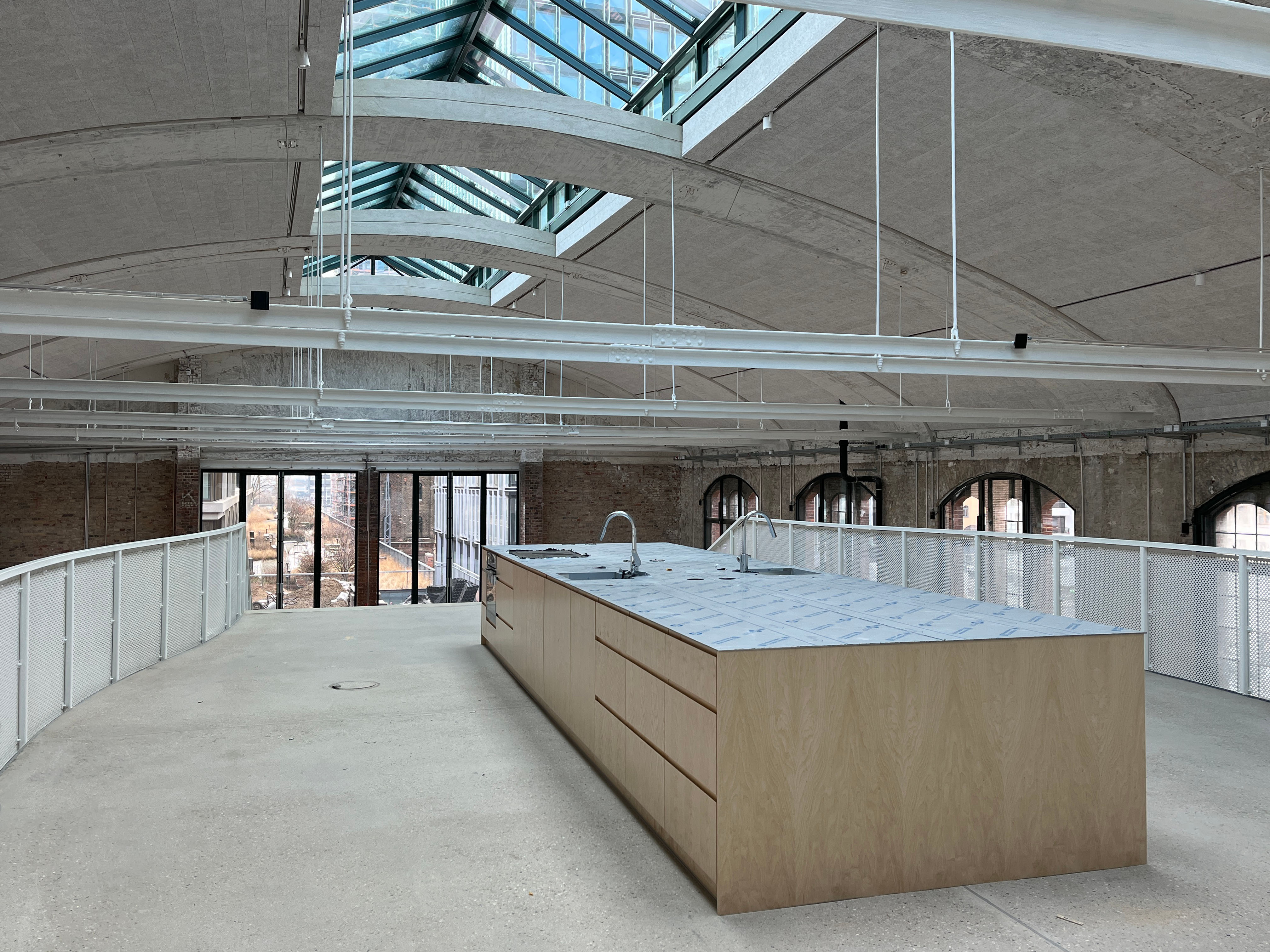 Das Bild zeigt den Baufortschritt im Postbahnhof Berlin mit der Galerie der Eingangspackkammer (EPK), sichtbarer Dachkonstruktion und neu eingebauten Raumelementen.