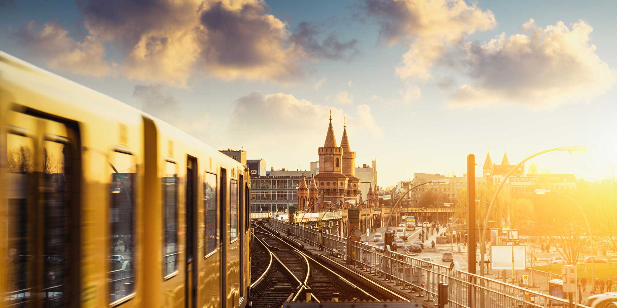 U-Bahn fährt bei Sonnenuntergang über die Oberbaumbrücke in Berlin.